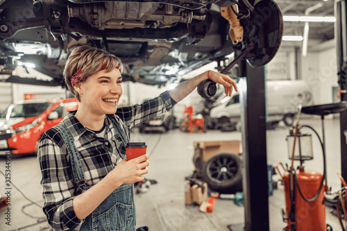 High-spirited woman standing in an auto workshop