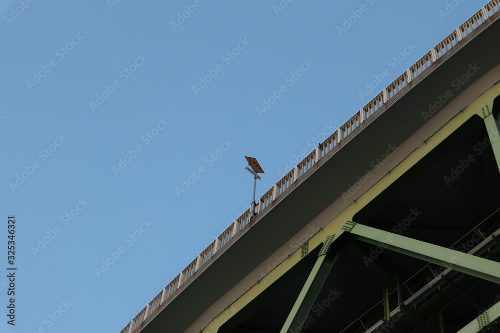 下から見上げた橋の横風注意の標識
