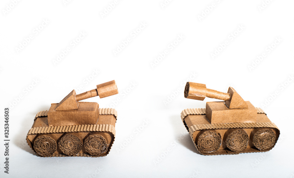 two toy tanks made by children from corrugated cardboard are fighting ...