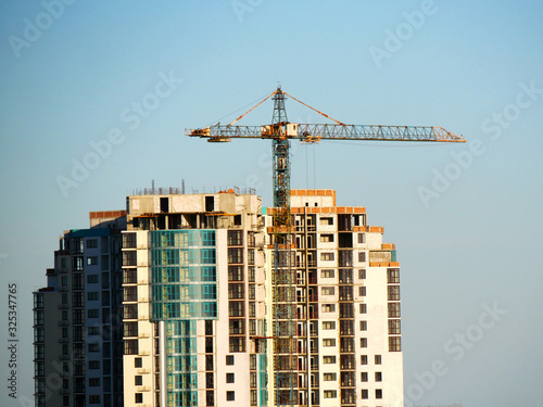Construction site background. Self-erecting crane near the building under construction. Industrial background.