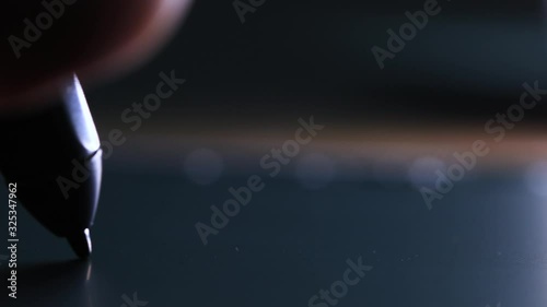 Hand of the designer with a pen on a tablet close up. 