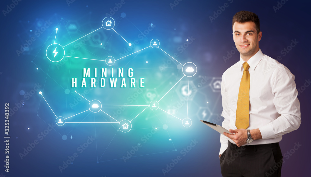 Businessman in front of cloud service icons with MINING HARDWARE inscription, modern technology concept Businessman in front of cloud service icons with MINING HARDWARE inscription, modern technology concept