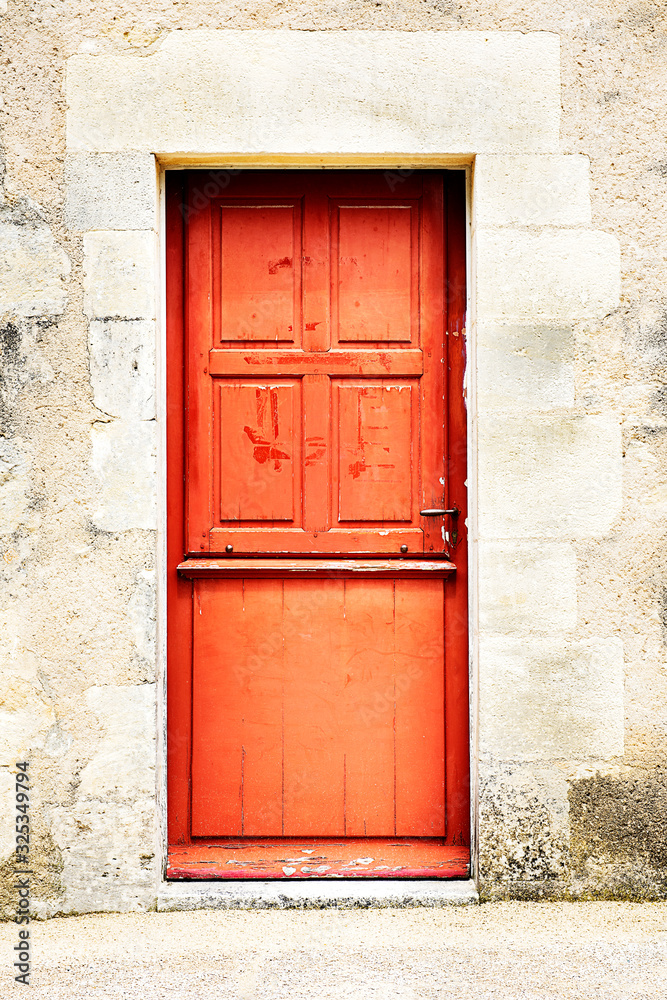 Weathered rustic woden front door of a stone built house in South Western France