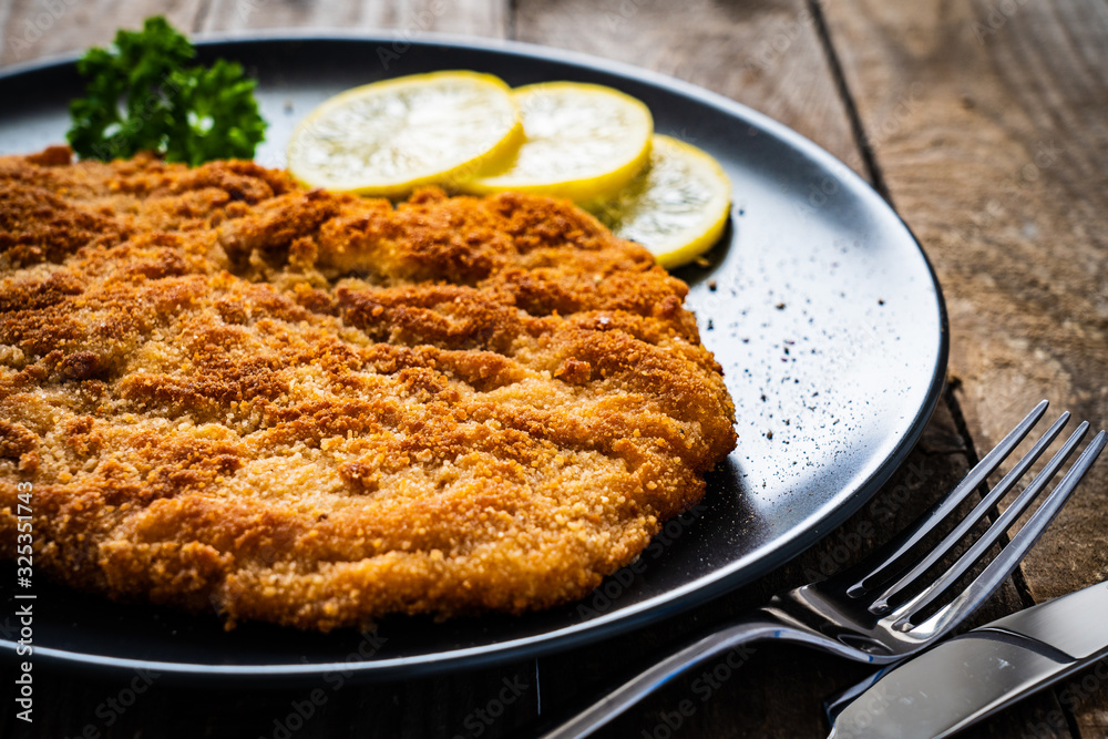 Schnitzel with  lemon on timber background