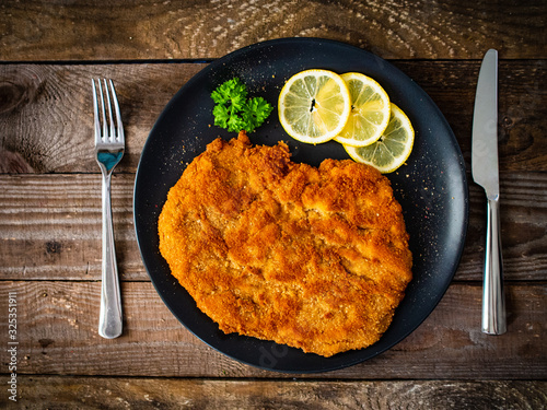 Schnitzel with  lemon on timber background