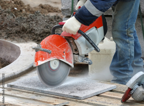 Worker cutting stone block by cutter machine