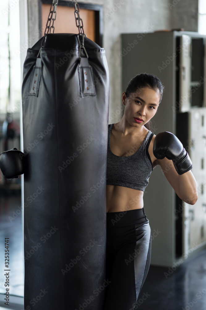 Sport woman hold punch bag in gym