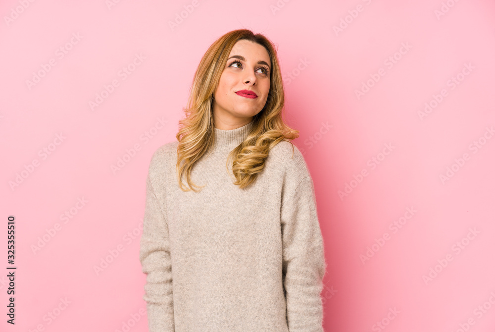 Young blonde cute woman wearing a sweater isolated dreaming of achieving goals and purposes Young blonde cute woman wearing a sweater isolated dreaming of achieving goals and purposes