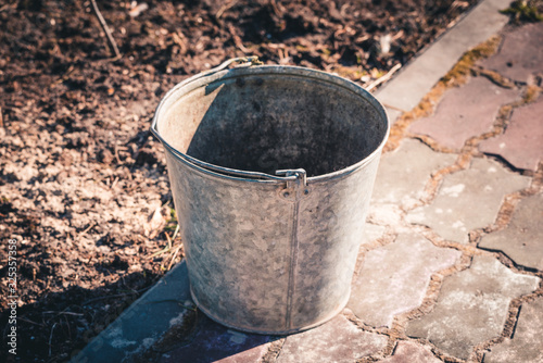 Iron bucket for cleaning garbage from the garden area. © Evgenii