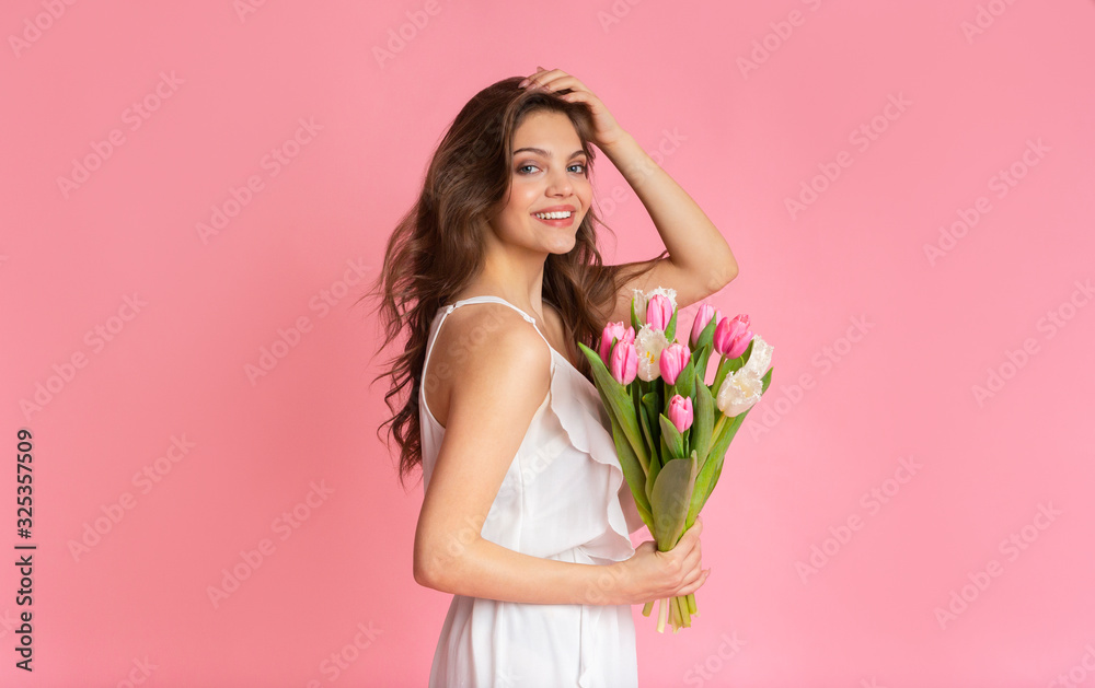 Beautiful woman in cocktail dress with tulips flower bouquet in hands