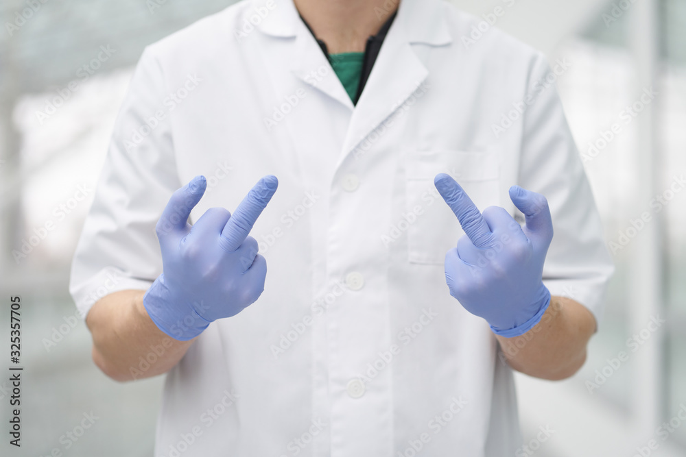 Medic shows middle fingers gesture by hands weared in medical gloves Medic shows middle fingers gesture by hands weared in medical gloves