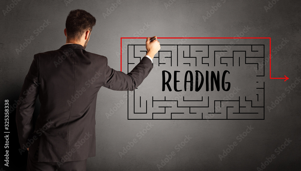 businessman drawing maze with READING inscription, business education concept