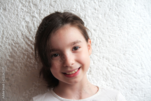 beautiful girl posing against a white wall photo