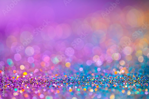 Decoration twinkle glitters background, abstract blurred backdrop with circles,modern design overlay with sparkling glimmers. Blue, purple and golden backdrop glittering sparks with glow effect photo