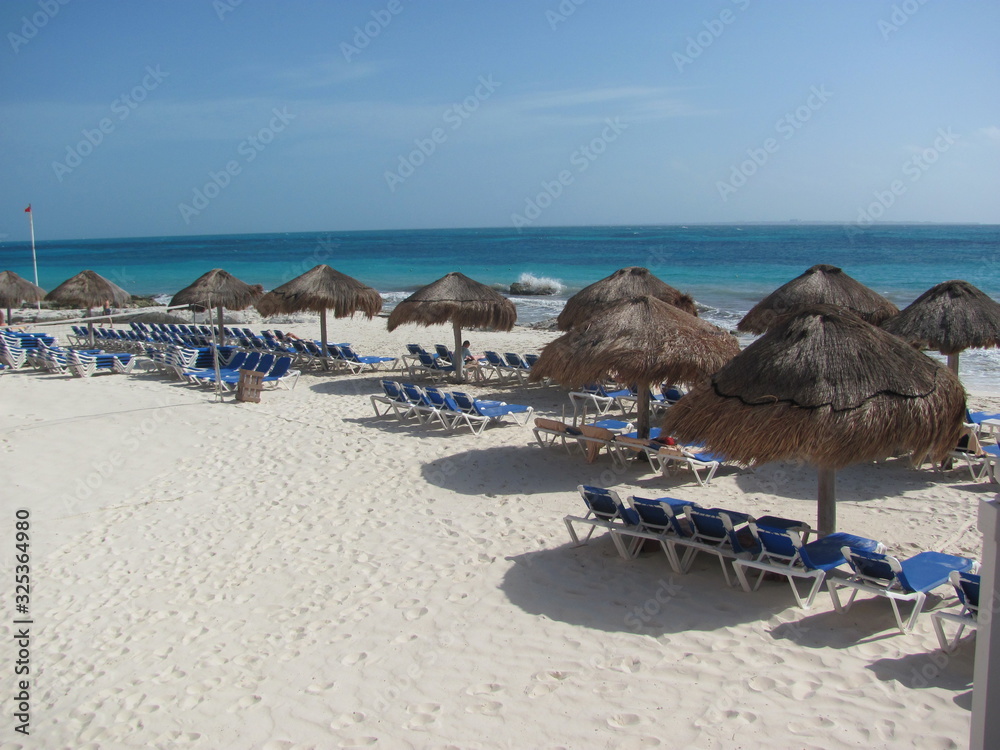 beach with lounge chairs and umbrellas