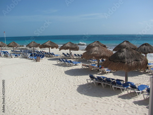 beach with lounge chairs and umbrellas
