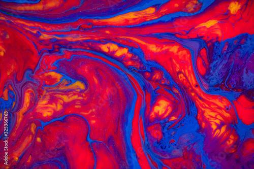 Fluid art texture. Abstract backdrop with mixing paint effect. Liquid acrylic picture with chaotic mixed paints. Can be used for posters or wallpapers. Red, blue and orange overflowing colors