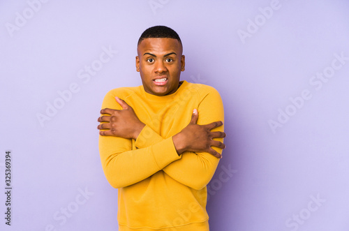 Murais de parede Young latin man isolated on purple background going cold due to low temperature or a sickness