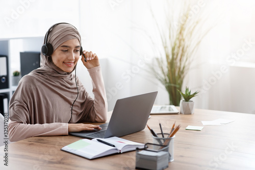 Arabic Businesswoman Using Laptop And Headset In Office, Having Video Call