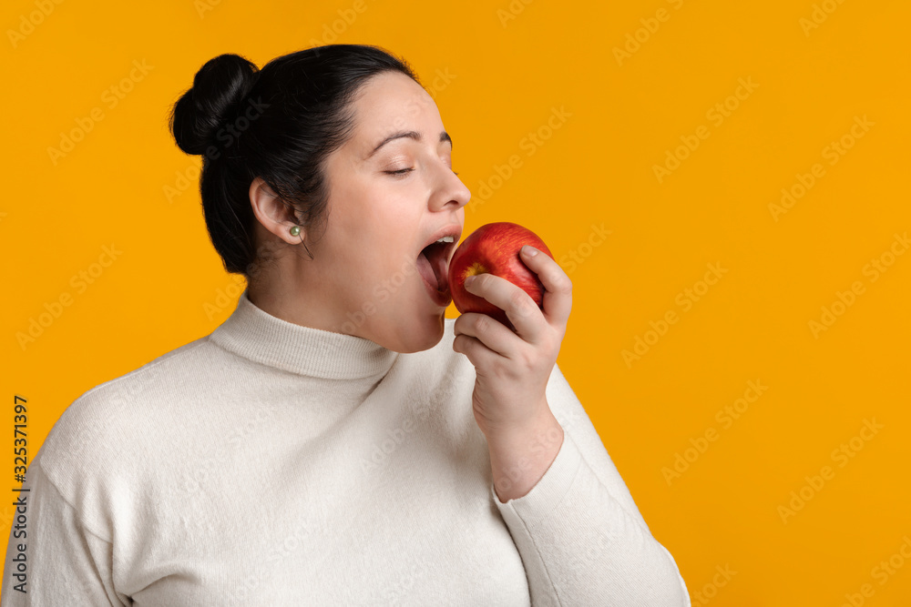 Portrait Of Young Plus Size Girl Biting Red Apple Portrait Of Young Plus Size Girl Biting Red Apple