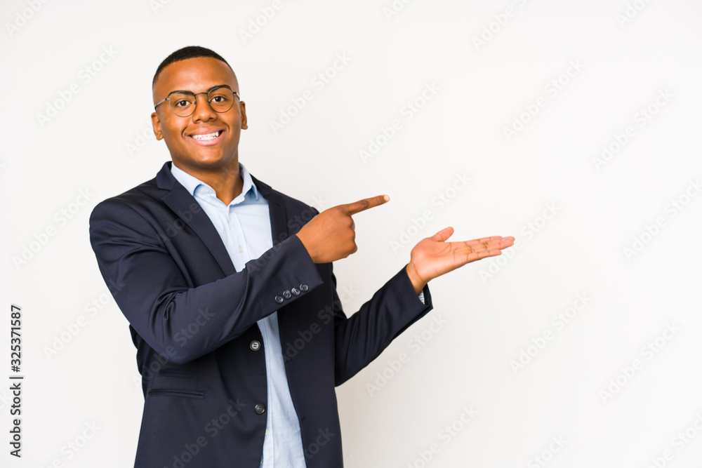 Young business latin man isolated on white background excited holding a copy space on palm. Young business latin man isolated on white background excited holding a copy space on palm.
