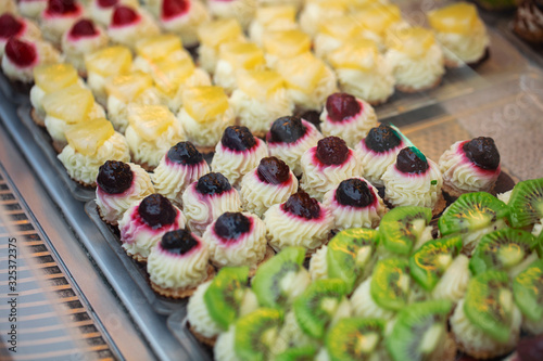 Various fresh pastries and desserts are on display in a bakery shop