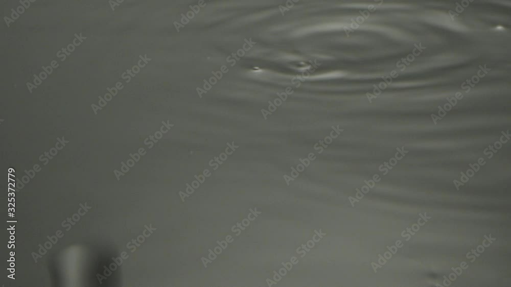 Drops of water dripping on a damp surface Drops of water dripping on a damp surface