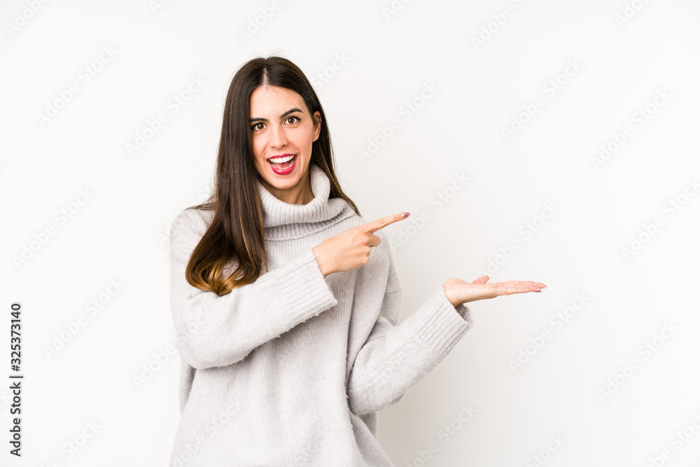 Young caucasian woman isolated on a white background excited holding a copy space on palm. Young caucasian woman isolated on a white background excited holding a copy space on palm.