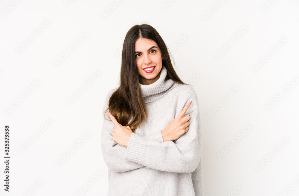 Young caucasian woman isolated on a white background points sideways, is trying to choose between two options. Young caucasian woman isolated on a white background points sideways, is trying to choose between two options.