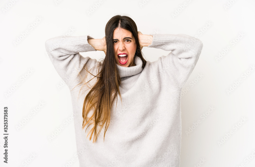 Young caucasian woman isolated on a white background covering ears with hands trying not to hear too loud sound. Young caucasian woman isolated on a white background covering ears with hands trying not to hear too loud sound.