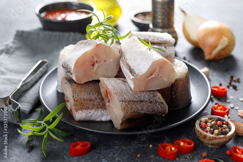 Raw fresh sliced hake fish with ingredients for cooking photo