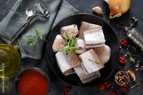 Raw fresh sliced hake fish with ingredients for cooking photo