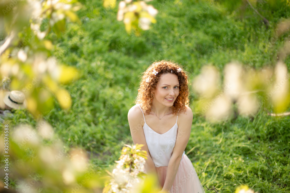 Young attractive girl walks in spring green park enjoying flowering nature. Healthy smiling girl spinning on the spring lawn. Allergy without Young attractive girl walks in spring green park enjoying flowering nature. Healthy smiling girl spinning on the spring lawn. Allergy without