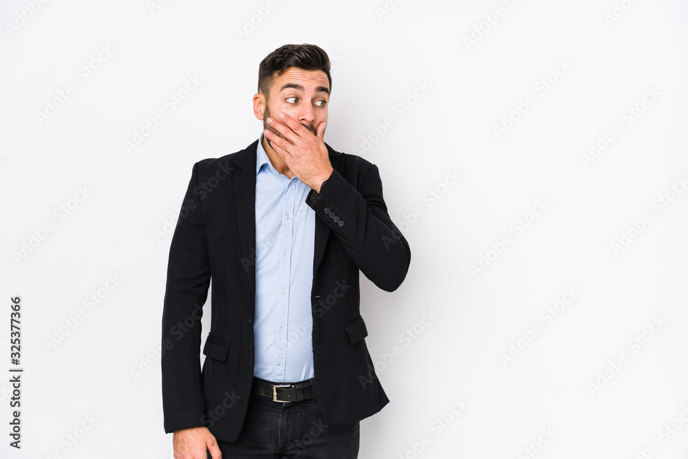 Young caucasian business man against a white background isolated thoughtful looking to a copy space covering mouth with hand. Young caucasian business man against a white background isolated thoughtful looking to a copy space covering mouth with hand.