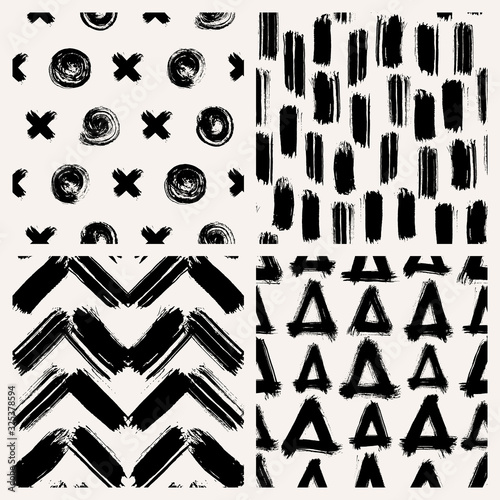 Set of 4 abstract vector seamless patterns with various shapes made with brush strokes. Hand-drawn grunge ink wallpapers. Creative repeating backgrounds.