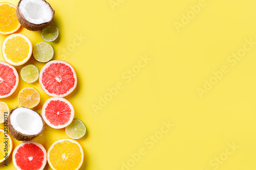 Summer vacation  cocktail  tropical beach. Composition with exotic fruits on yellow background. Summertime creative layout  copy space for text design