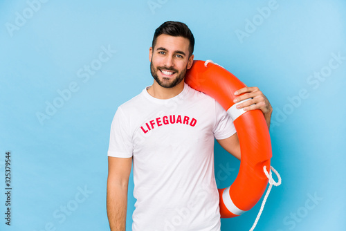 Young handsome lifeguard man isoalted happy, smiling and cheerful. photo