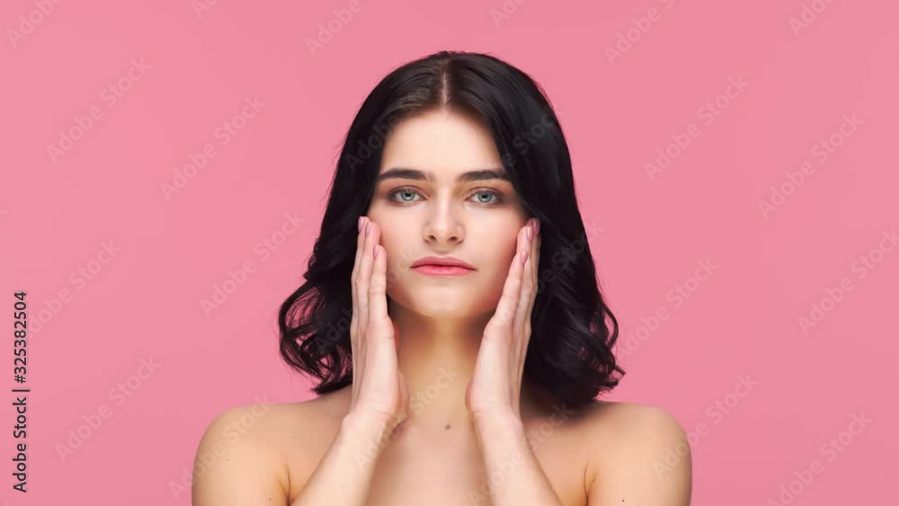 Studio portrait of young and beautiful brunette woman over pink background. Skin care, health, makeup and cosmetics. Studio portrait of young and beautiful brunette woman over pink background. Skin care, health, makeup and cosmetics.
