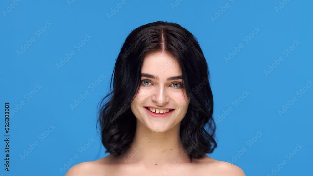 Studio portrait of young and beautiful brunette woman over blue background. Skin care, health, makeup and cosmetics. Studio portrait of young and beautiful brunette woman over blue background. Skin care, health, makeup and cosmetics.