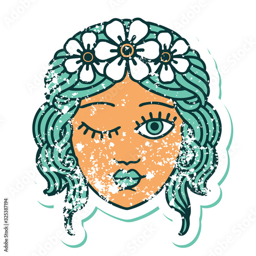 distressed sticker tattoo style icon of a maidens face winking