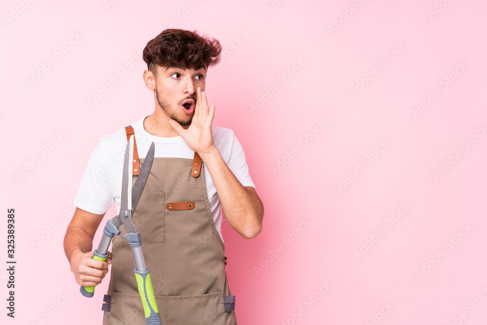 Young arab gardener man isolated is saying a secret hot braking news and looking aside Young arab gardener man isolated is saying a secret hot braking news and looking aside