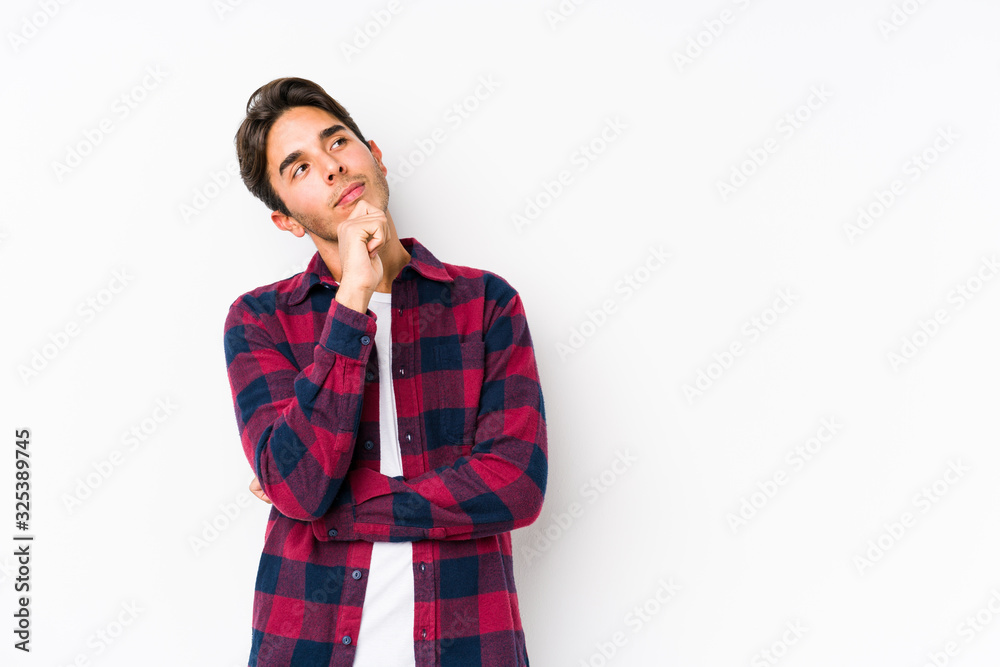 Young caucasian man posing in a pink background isolated looking sideways with doubtful and skeptical expression. Young caucasian man posing in a pink background isolated looking sideways with doubtful and skeptical expression.