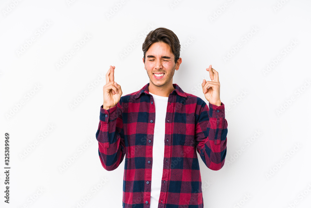 Young caucasian man posing in a pink background isolated crossing fingers for having luck Young caucasian man posing in a pink background isolated crossing fingers for having luck