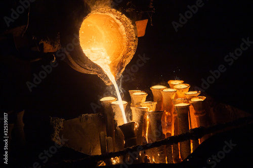 Industrial lost wax casting. The process of pouring for filling out ceramic shells with molten steel. photo