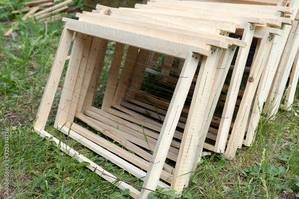 Wooden frames new to honey. Beekeeping, a tool for bees. Frames lie on the green grass, preparation for the work of the beekeeper. No honey.