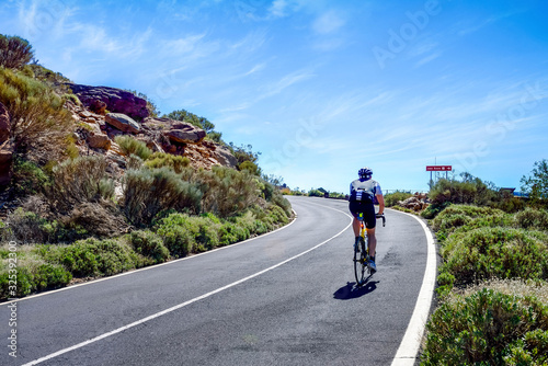 Fototapeta Naklejka Na Ścianę i Meble - cyclist on the roads crossing the beautiful desert landscape on the island of Tenerife