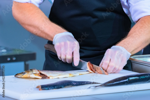 The cook was slicing fish. ...