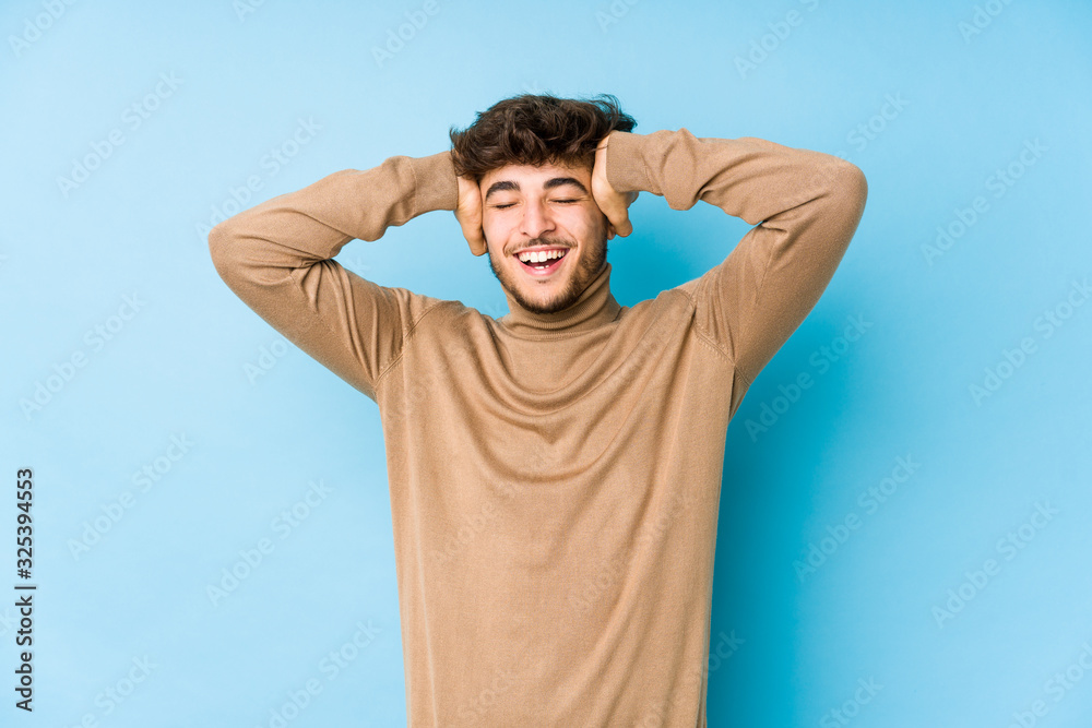 Young arabian man isolated laughs joyfully keeping hands on head. Happiness concept.