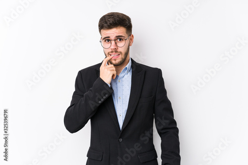 Young caucasian business man posing in a white background isolated Young caucasian business man biting fingernails, nervous and very anxious.