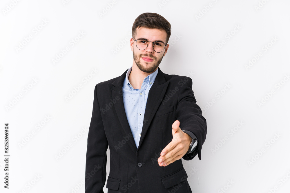 Young caucasian business man posing in a white background isolated Young caucasian business man stretching hand at camera in greeting gesture. Young caucasian business man posing in a white background isolated Young caucasian business man stretching hand at camera in greeting gesture.